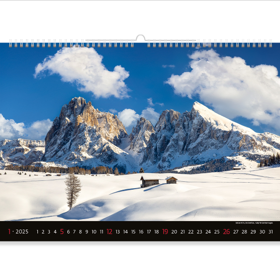Winter mountains bathed in bright sunshine. At the foot of the mountain, a lonely cabin looks so small against the majestic cliffs. Experience the charm of winter and the majesty of ancient mountains with the Mountain View calendar 2025.