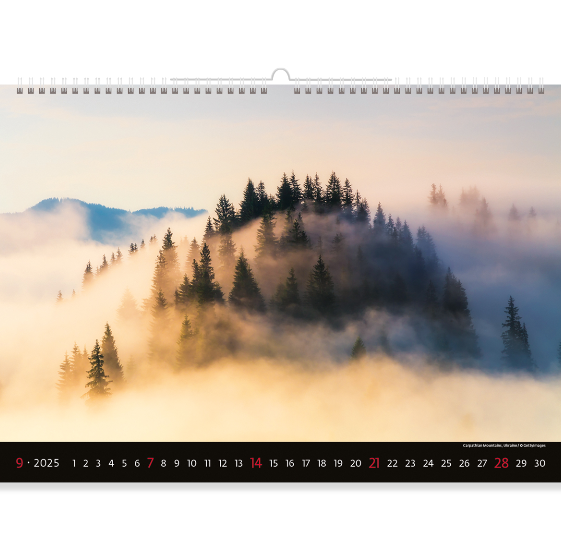 A misty landscape of high mountains in the rays of the dawn sun. The morning is coming and soon the forest will awaken from its sleep. This magical moment is captured in our Mountain view calendar 2025.